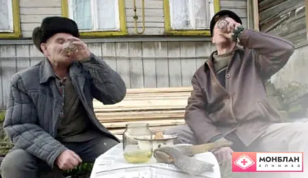 Двое мужчин пьют водку на улице